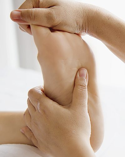 Woman receiving foot massage service from masseuse close up at hand and foot - relax in foot massage therapy service concept